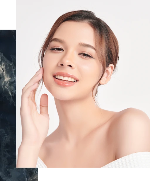 Woman touching her face with a relaxed smile, demonstrating smooth skin