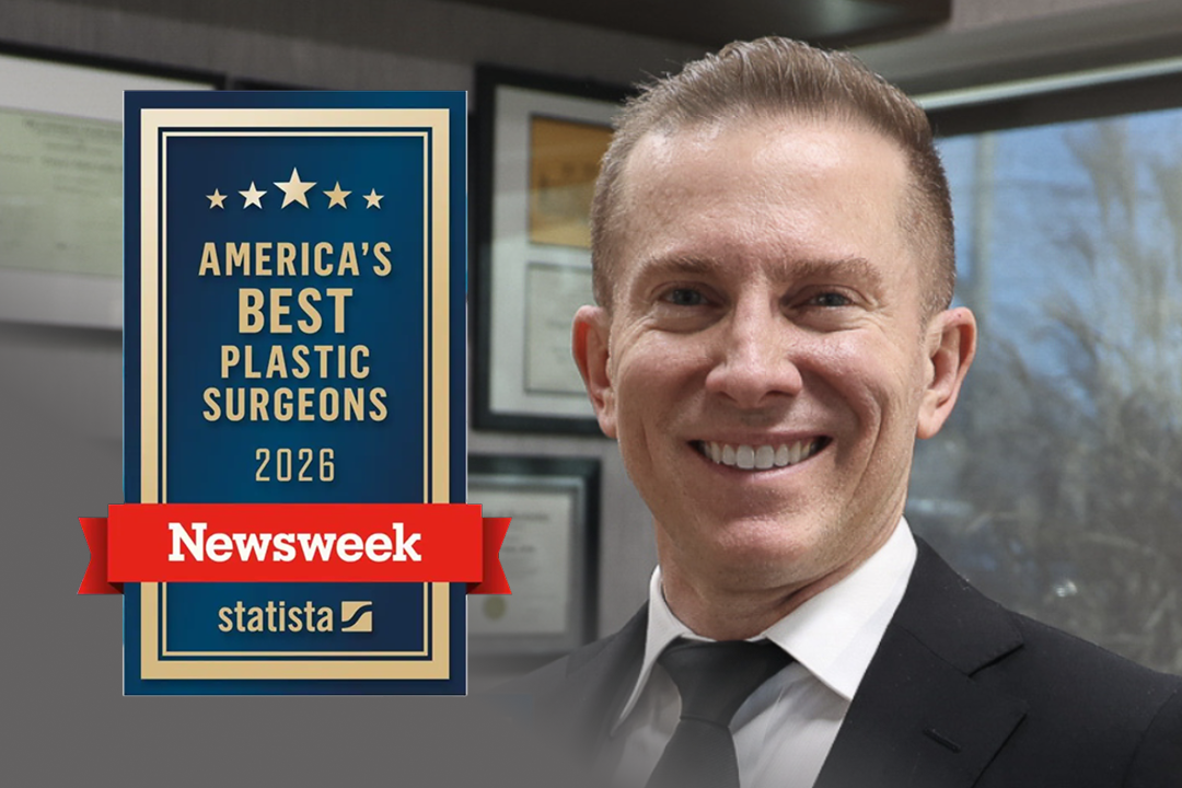 Male plastic surgeon smiling in office with America's Best Plastic Surgeons 2026 Newsweek award badge