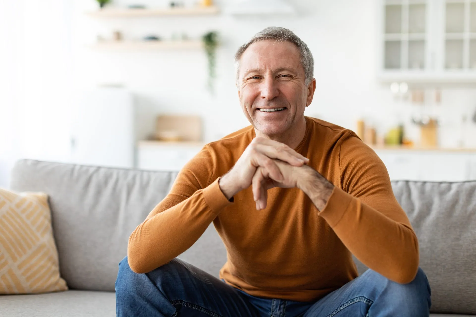smiling mature man sitting couch posing