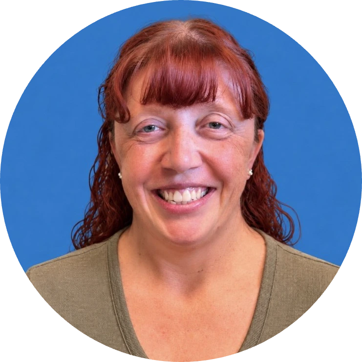 Headshot of a smiling woman with reddish-brown wavy hair against a blue background