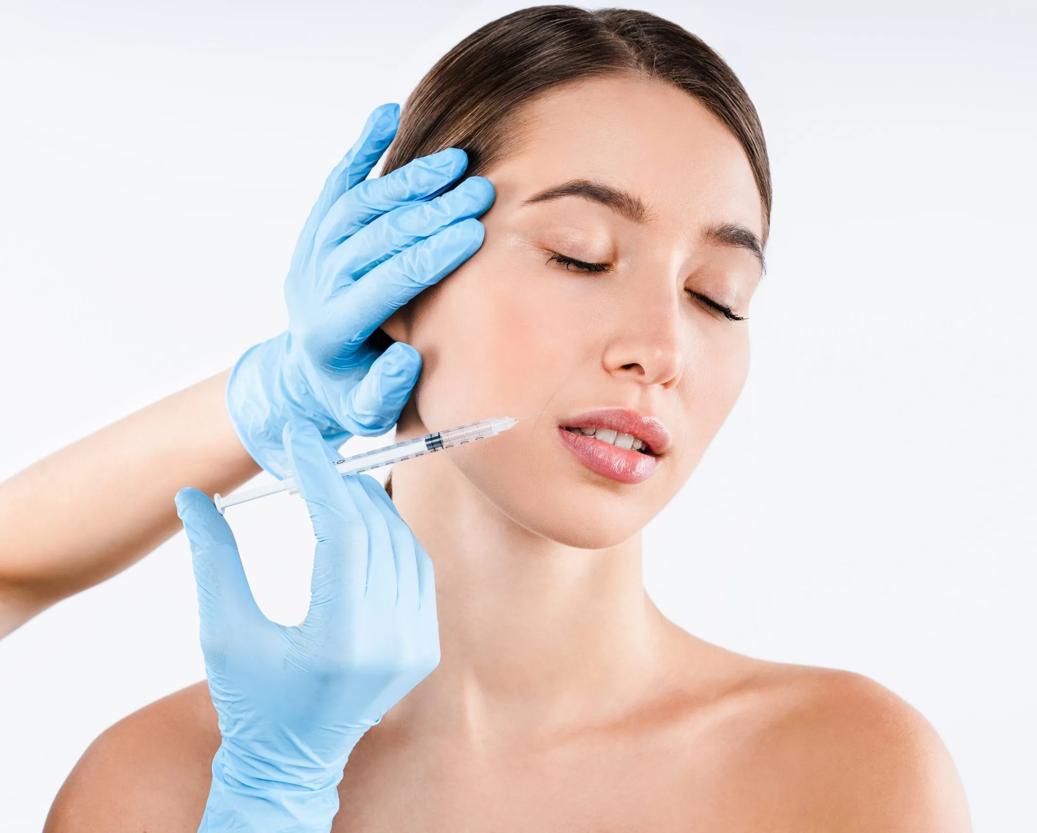 Clinician in blue gloves administering lip filler injection to a woman's mouth