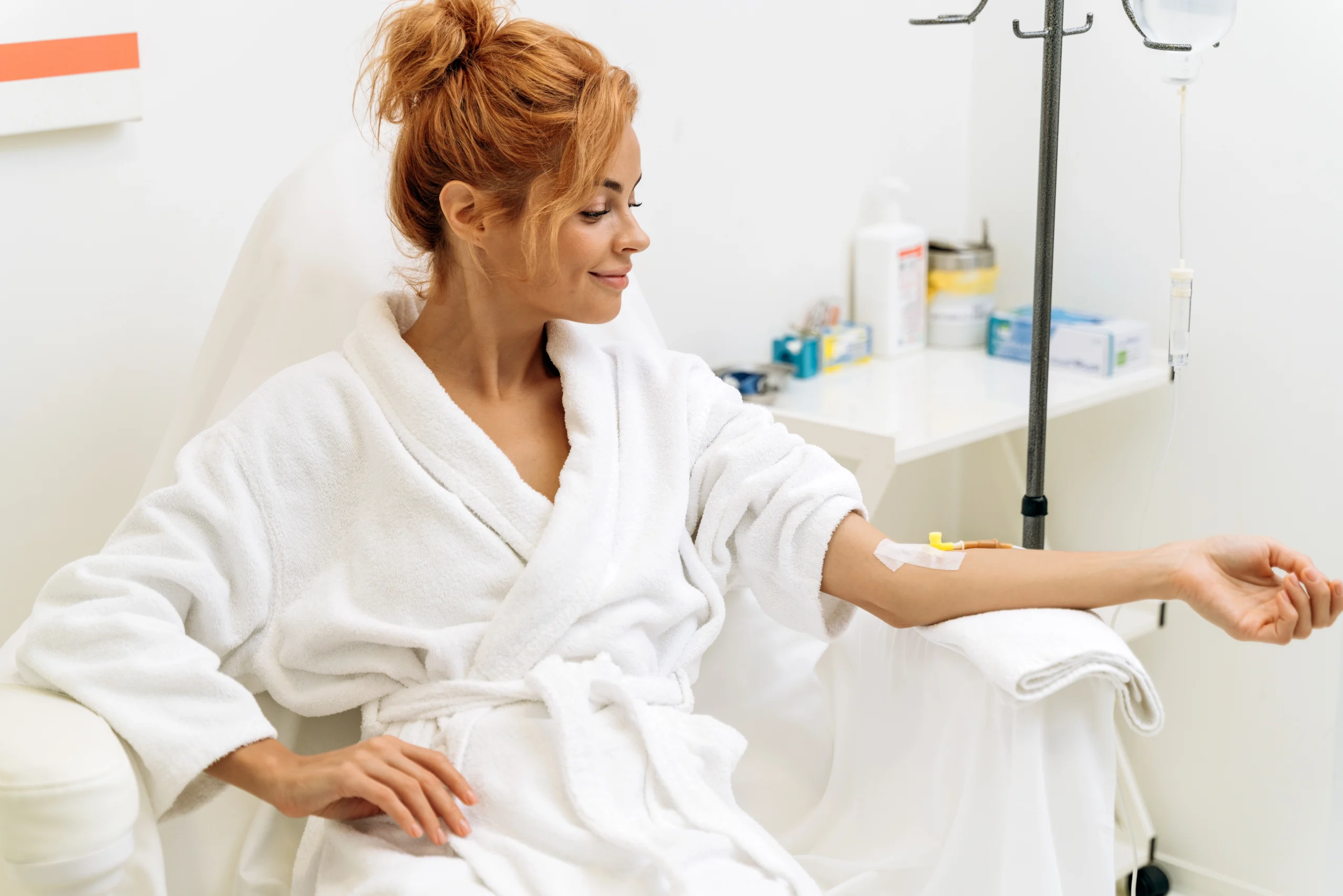Woman relaxing in a robe while receiving IV therapy