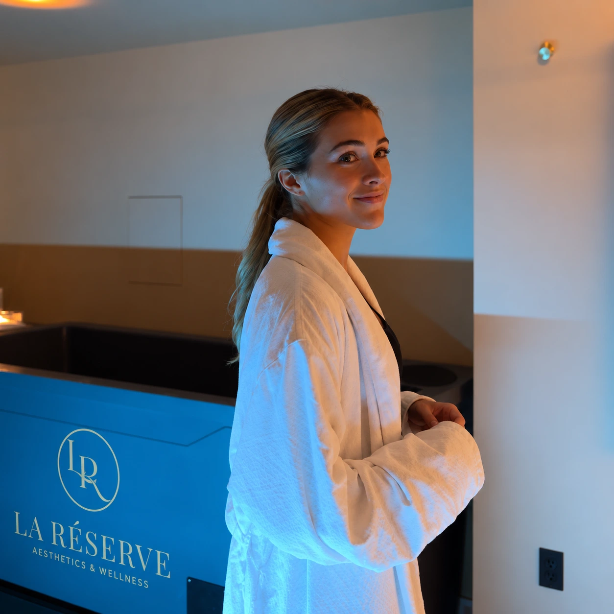 Guest in a white robe beside the cold plunge at La Reservé