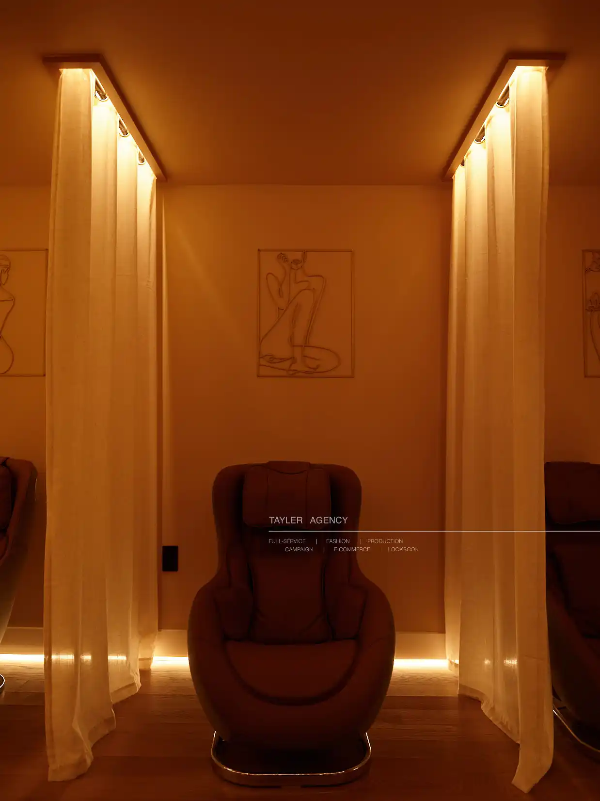 Warm-lit IV therapy treatment room with burgundy chair between illuminated curtain dividers