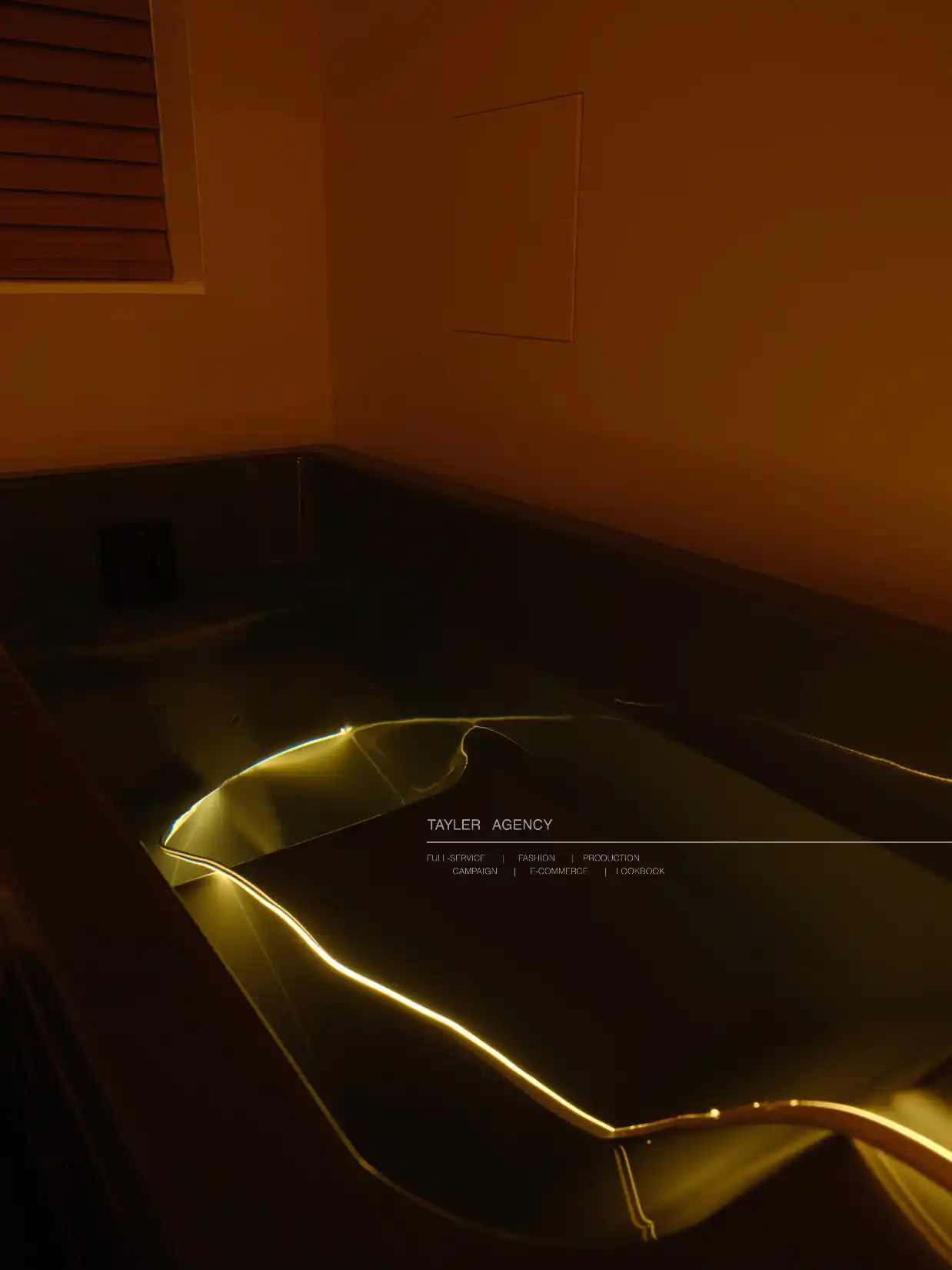 Cold plunge tub with glowing yellow lighting in a warm-toned spa room