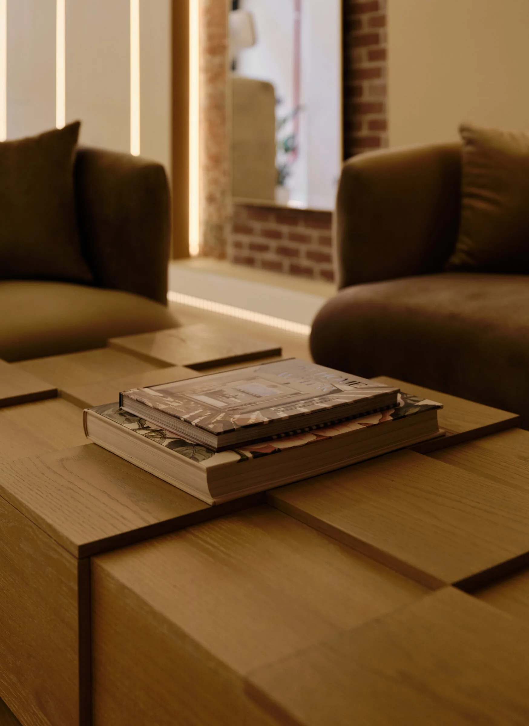 La Reservé Aesthetics and Wellness consultation room with stacked magazines on wooden table and brown leather seating