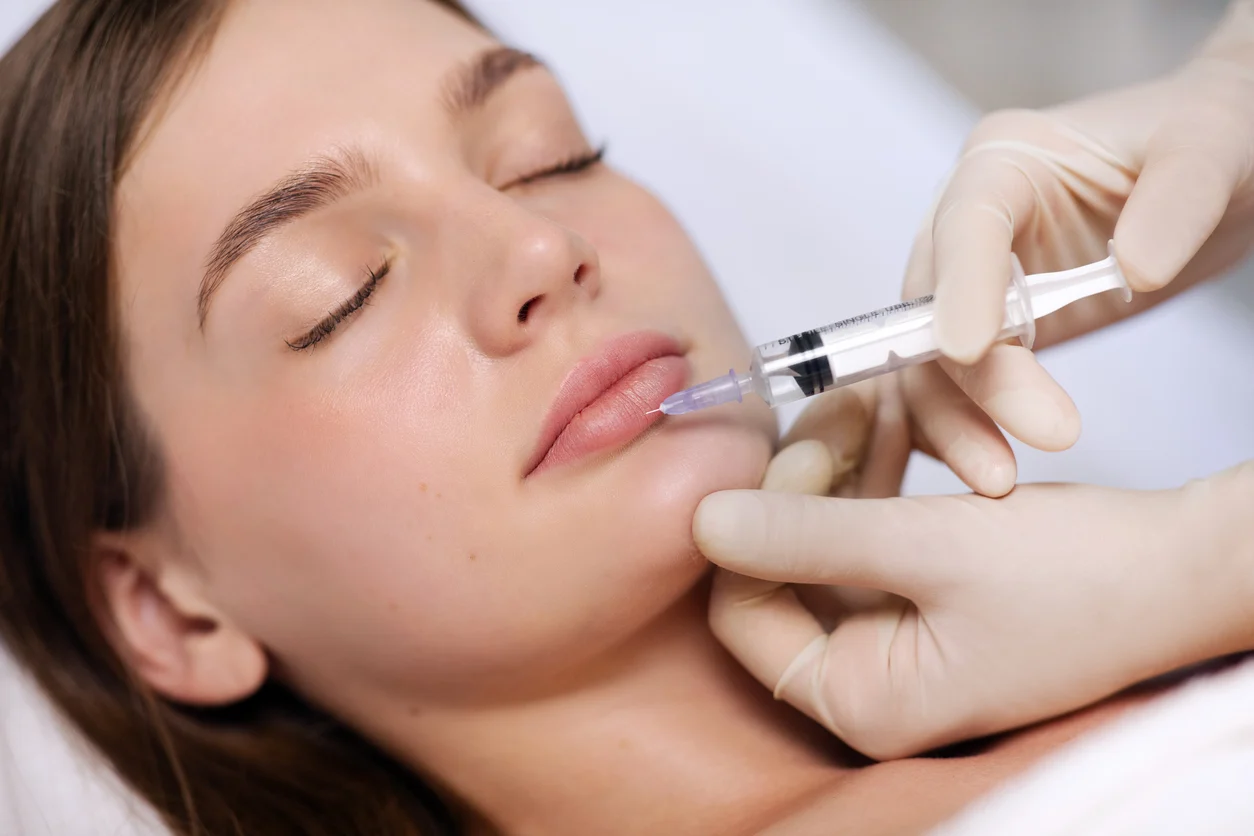 Lip filler being injected into a relaxed patient’s upper lip