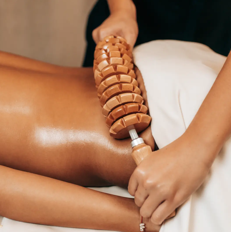 Practitioner using segmented roller device on patient's arm during skin rejuvenation treatment