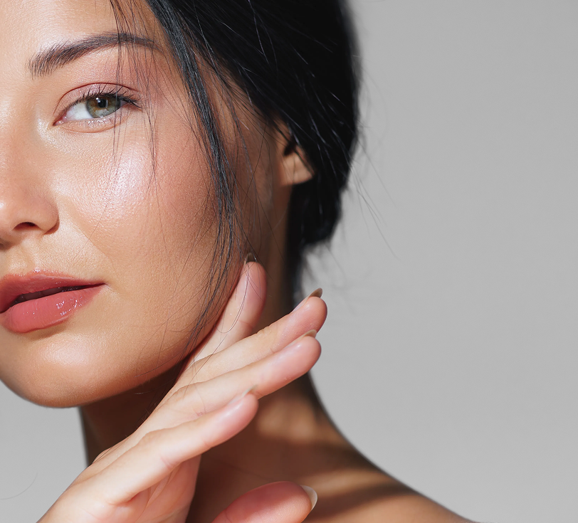 Woman touching her face, displaying smooth, tightened skin on cheek and jawline