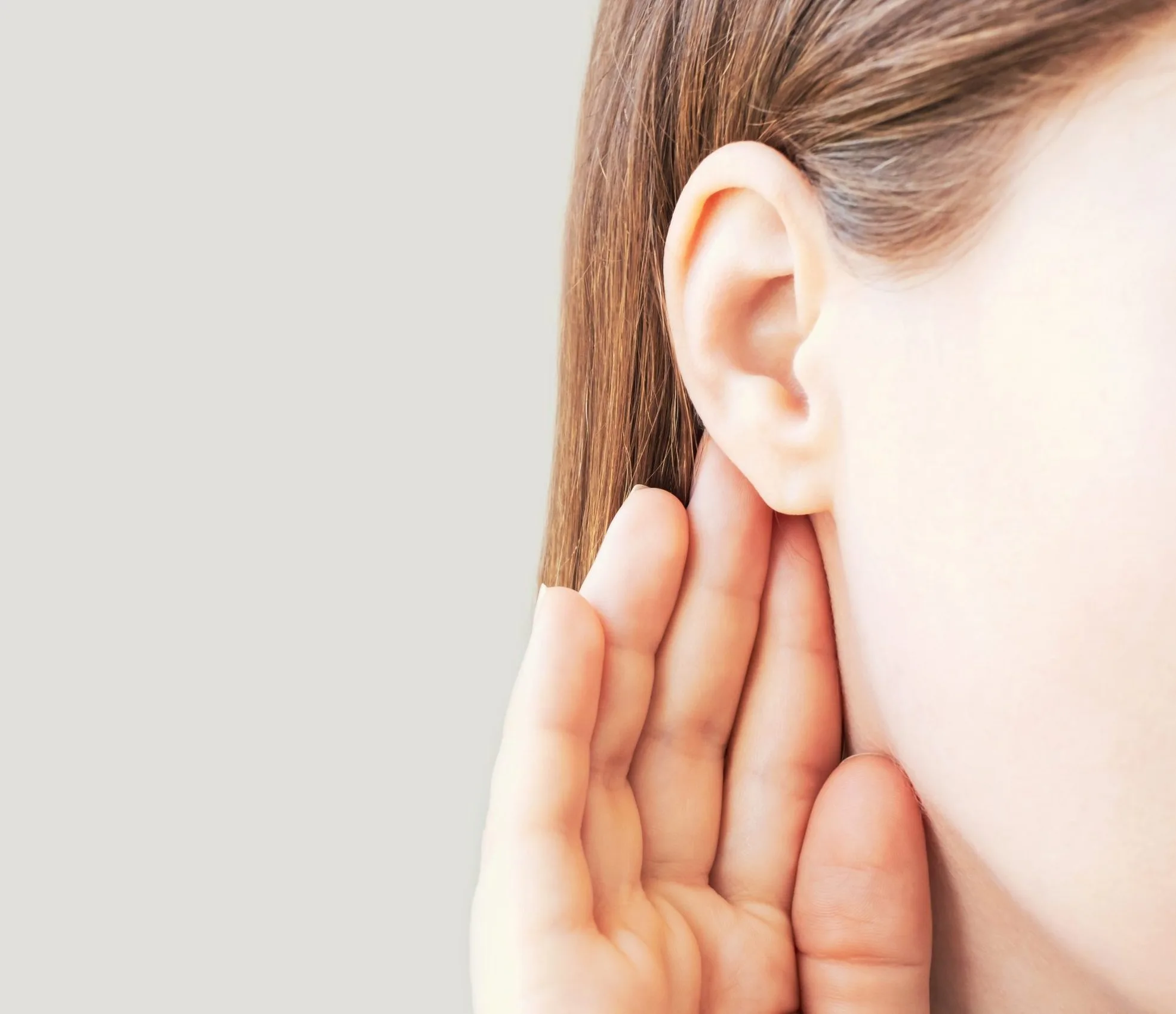 Person touching their ear, showing the earlobe from the side