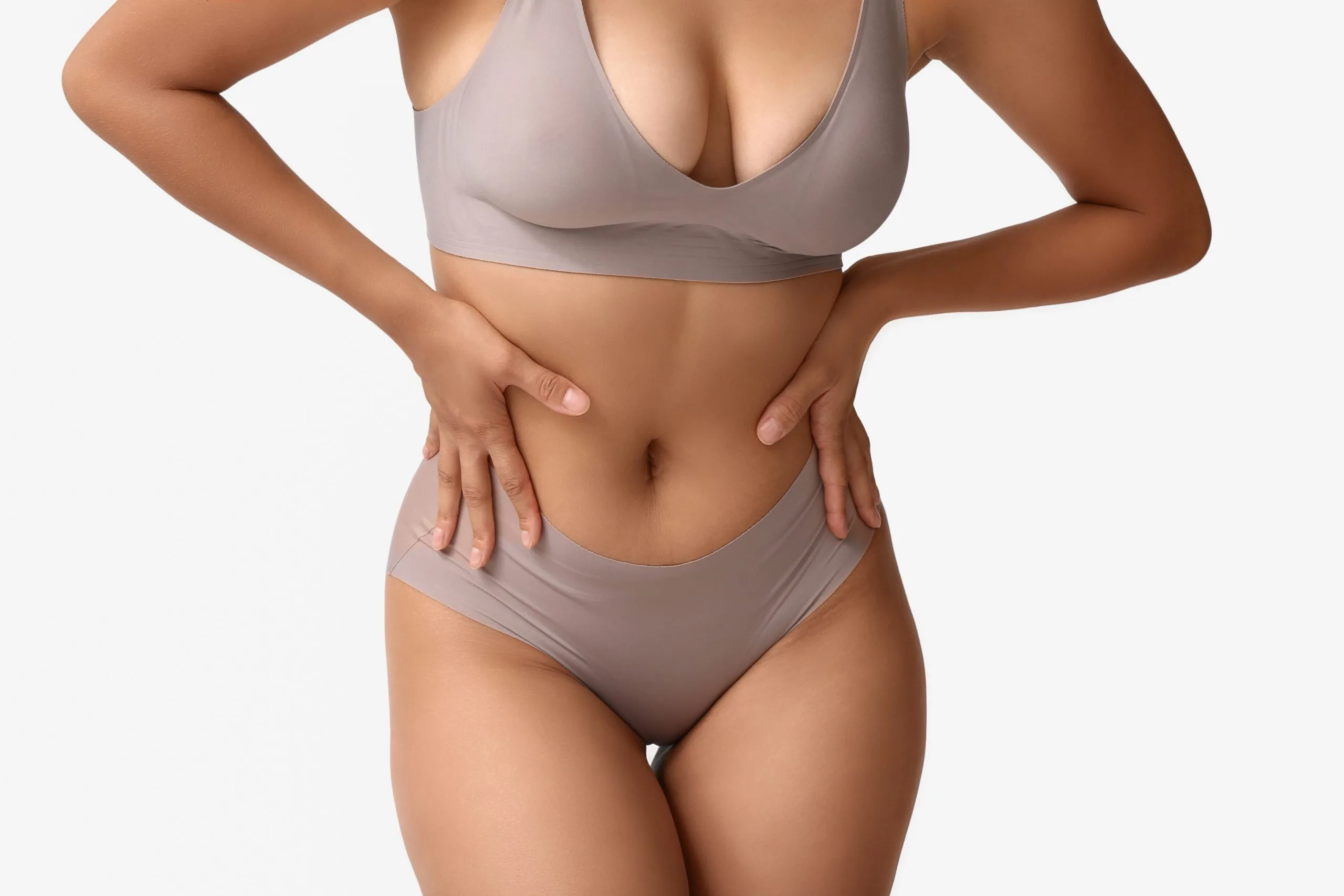 Woman in neutral-toned underwear demonstrating abdominal and torso area