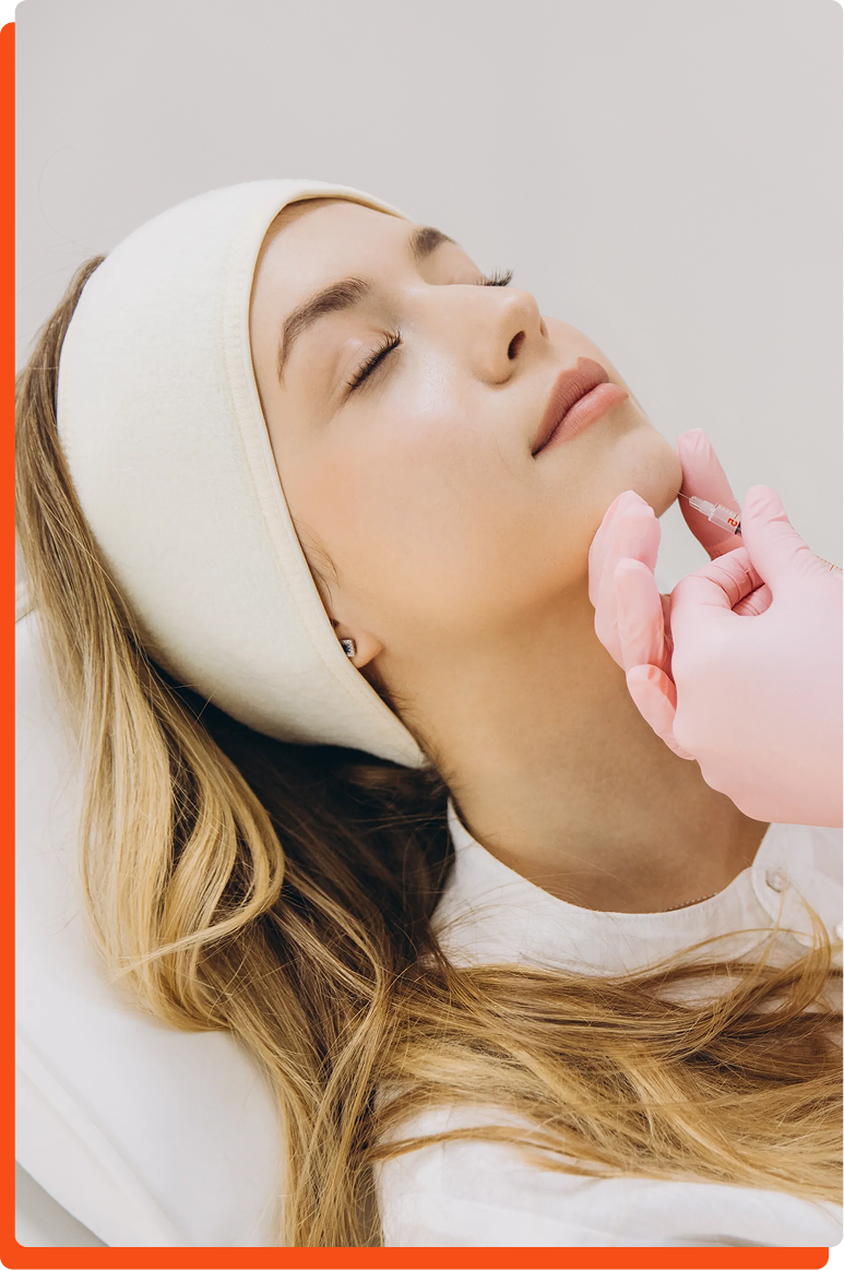 Gloved hands injecting filler into woman's jawline during aesthetic procedure