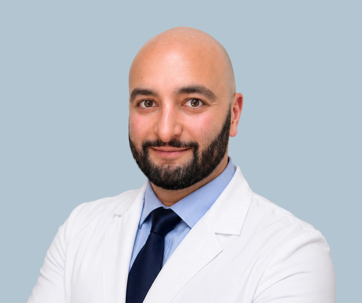Dr. Jonathan Shalot portrait in white coat and blue tie against light blue background