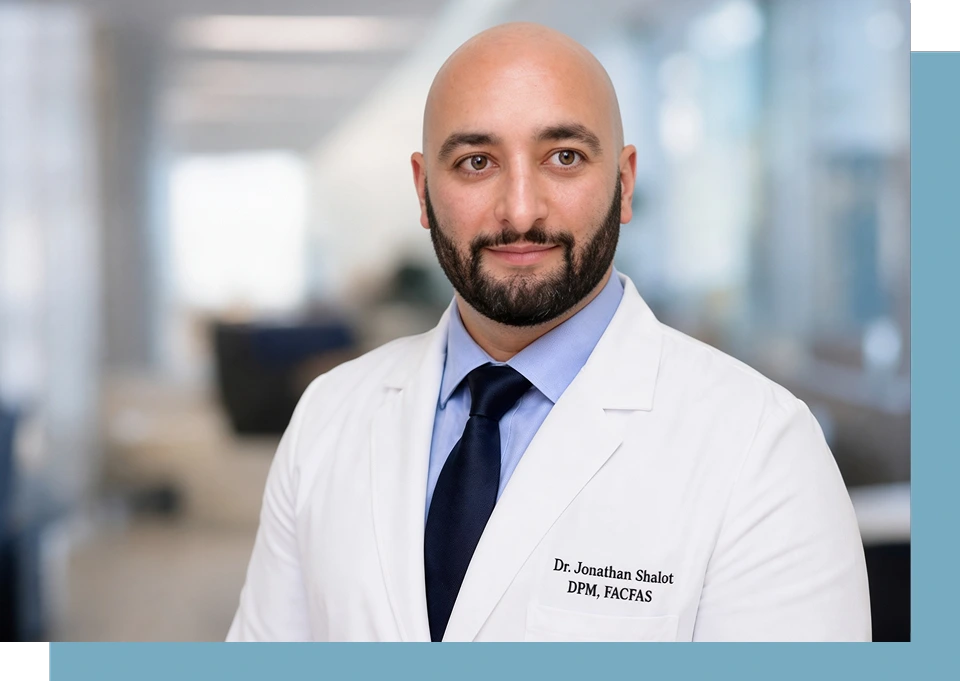 Dr. Jonathan Shalot, DPM, FACFAS, in white coat at modern clinic interior