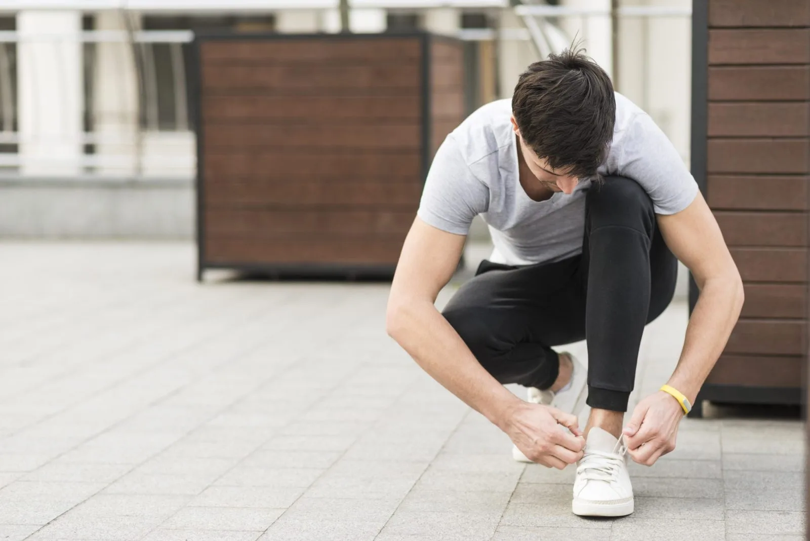 Man tying running shoes outdoors — minimally invasive bunion surgery NYC