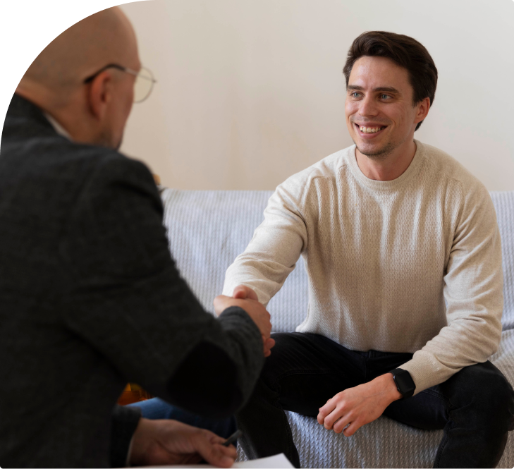Psychiatrist shaking hands with a smiling patient during a psychiatric evaluation