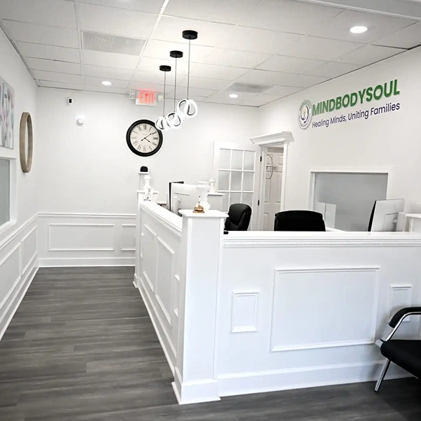 MindBodySoul Decatur clinic reception area with white paneling, pendant lighting, and front desk