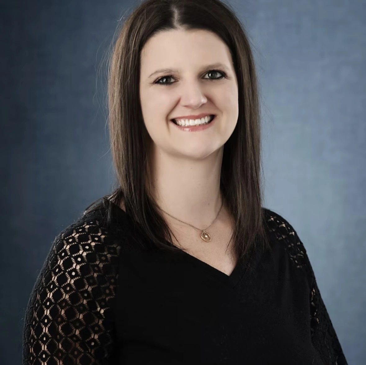 Elizabeth Byrne, team member, smiling at camera against blue background