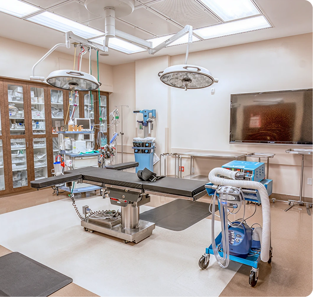 Surgical operating room with two overhead lights, surgical bed, monitoring equipment, and supply cabinets