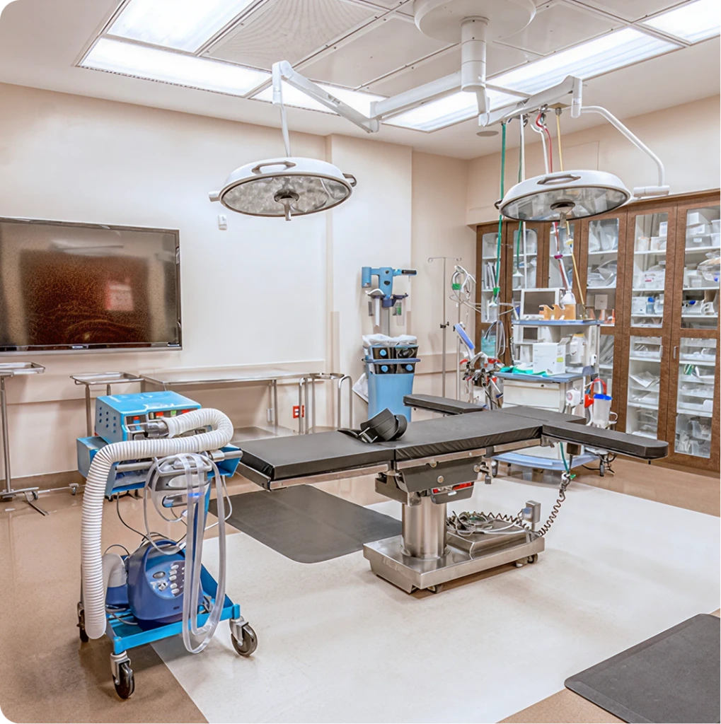 Surgical operating room with overhead lights, surgical bed, anesthesia equipment, and instrument cabinets