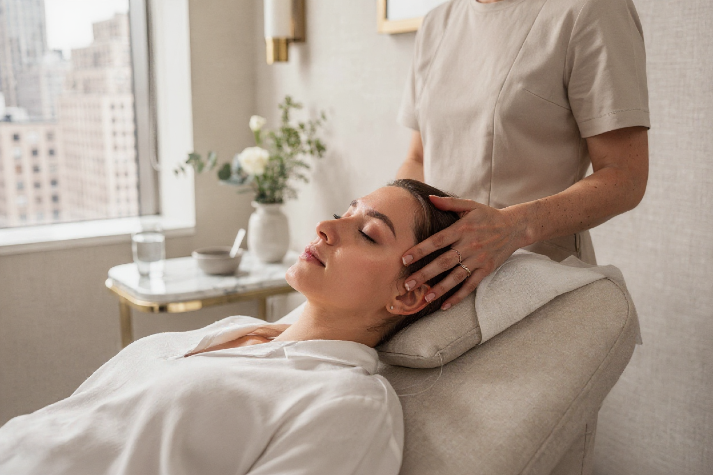 Practitioner performing a facial massage on a relaxed patient during a rosacea treatment consultation