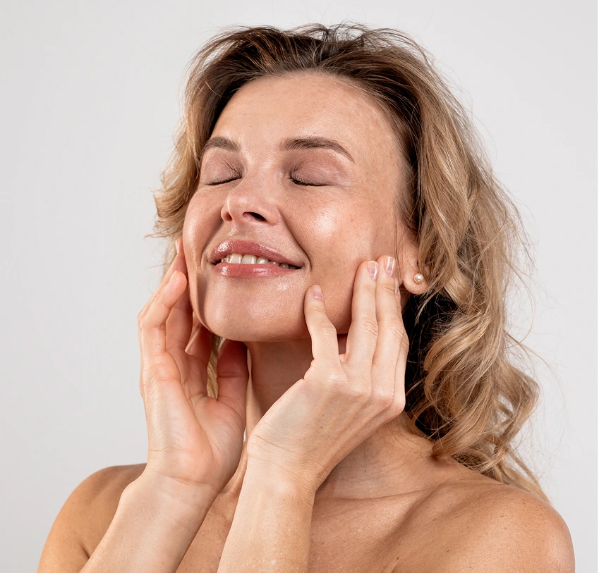 Woman with hands on face demonstrating skin texture and radiance after laser resurfacing treatment