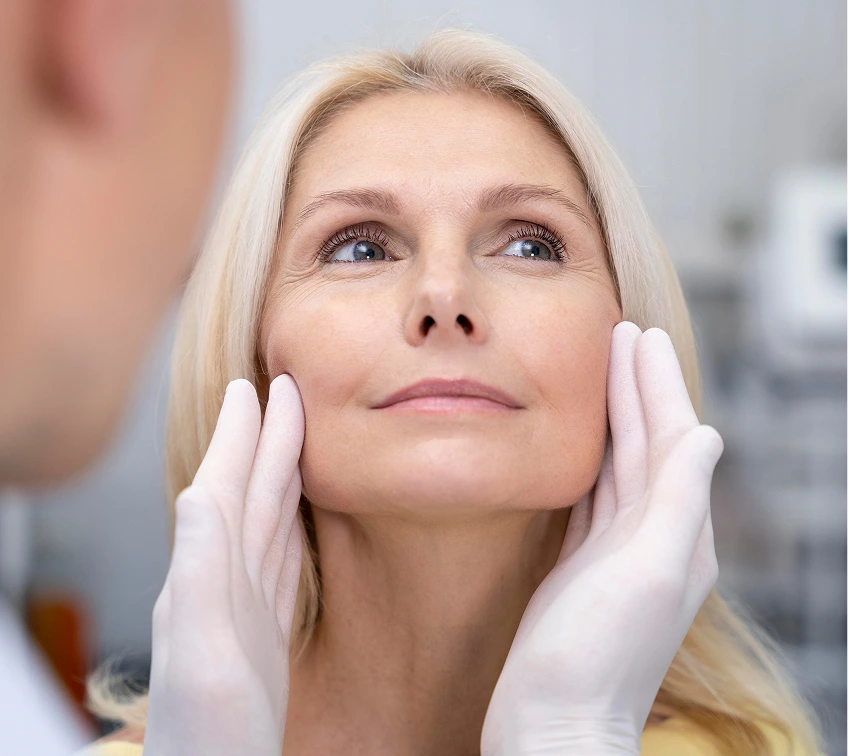 Woman examining her skin texture on her cheeks during a PRX treatment consultation