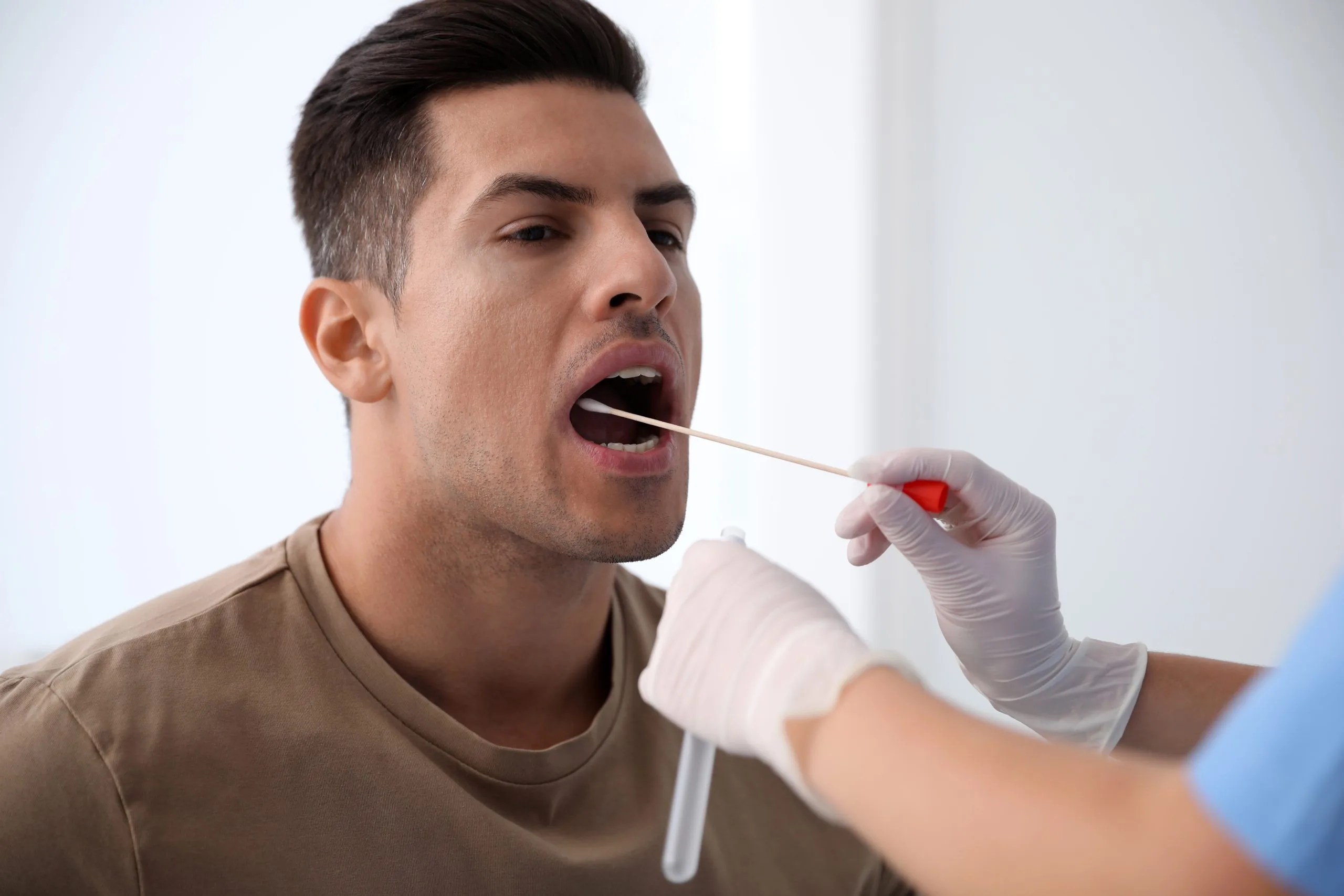 Healthcare provider collecting a DNA swab sample from a patient's mouth