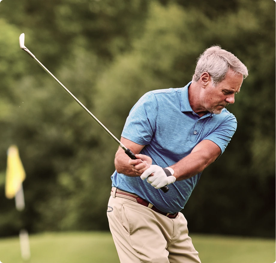 Man playing golf on sunny course, demonstrating active recovery