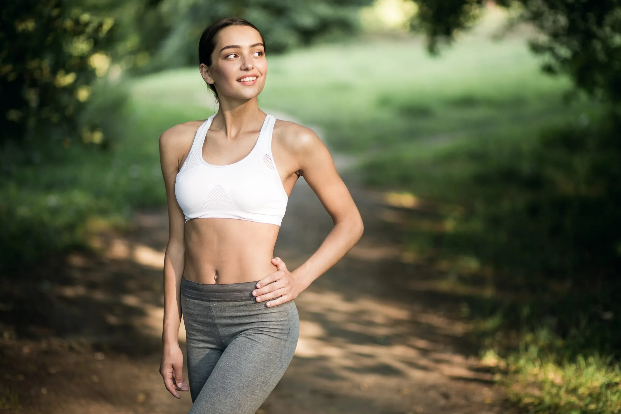 Fit woman in athletic wear jogging through a park
