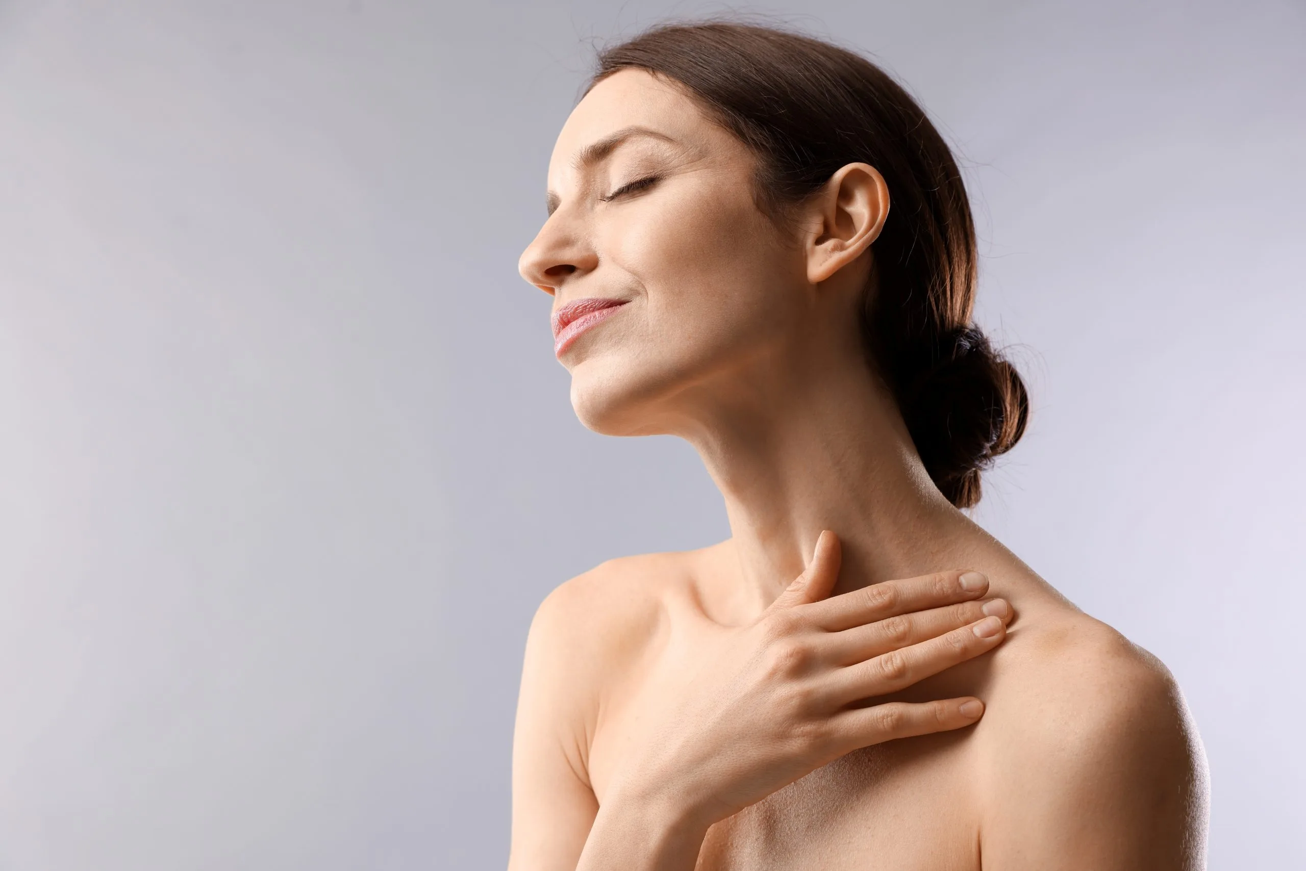 Woman in profile with hand on chest, eyes closed