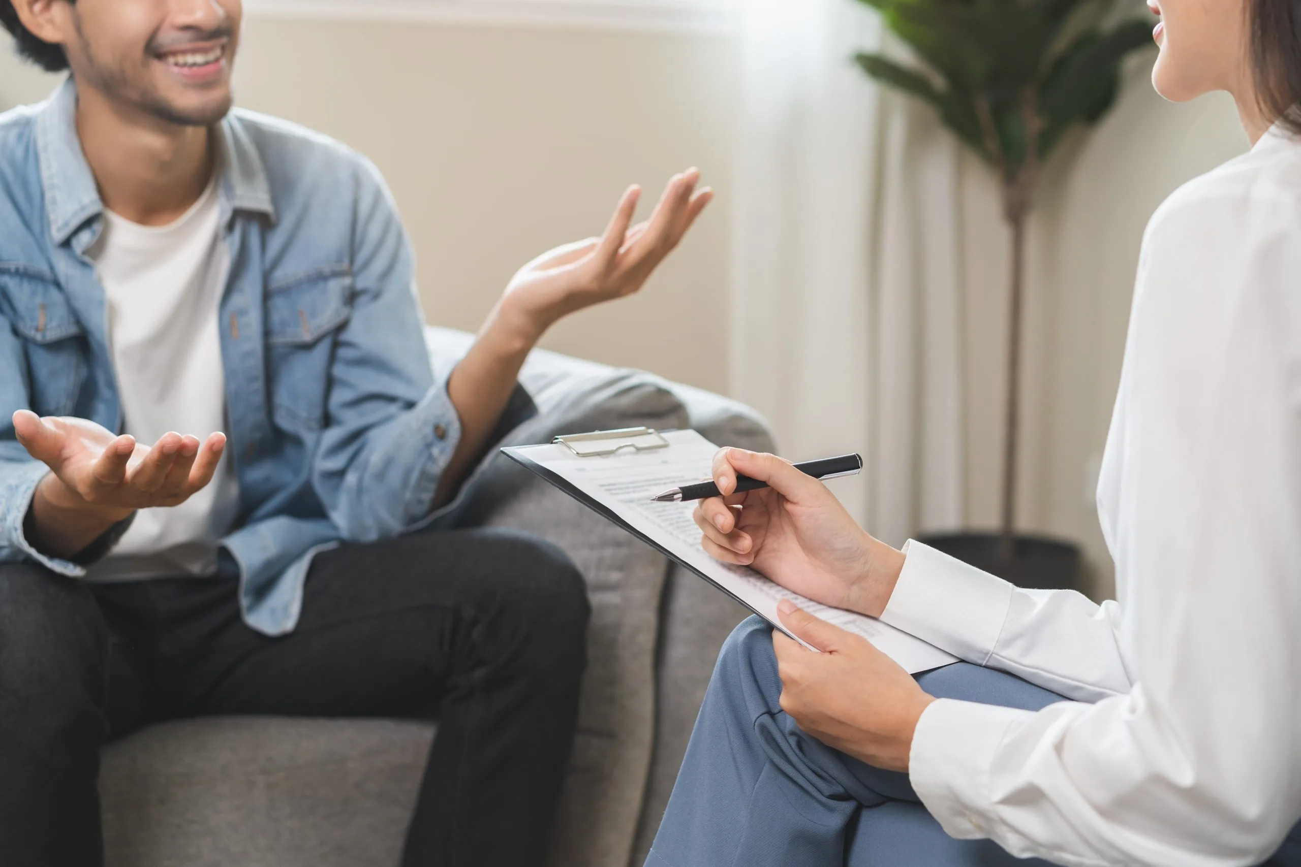 Patient discussing treatment plan with healthcare provider holding clipboard