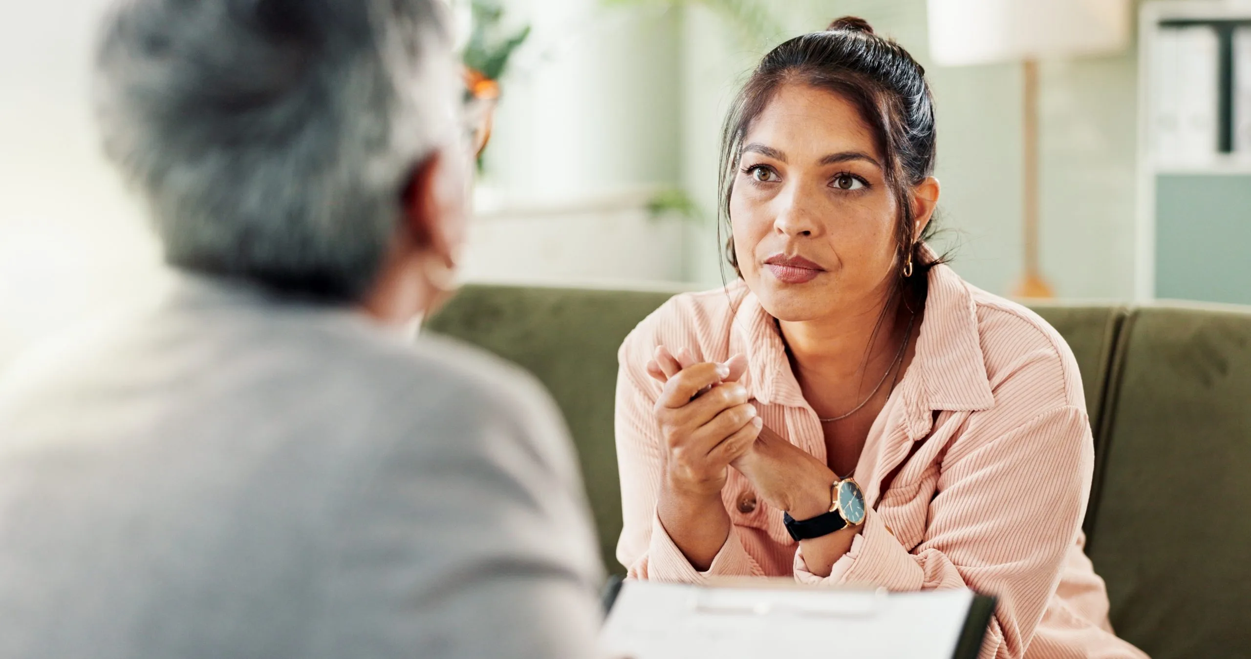 Therapist taking notes while listening to patient during consultation