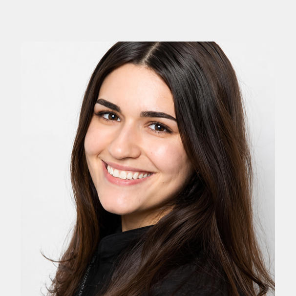 Woman with long dark hair smiling at camera against white background