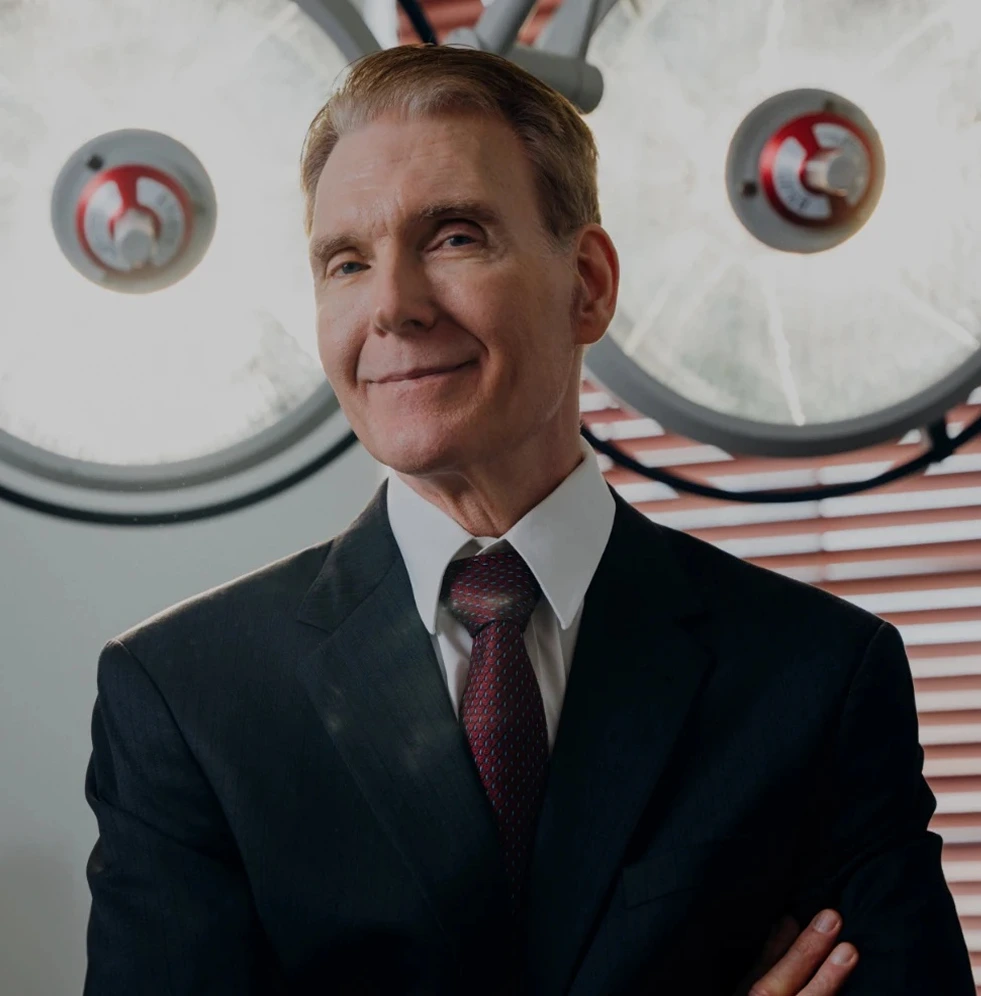 Man in business suit standing in medical office with overhead surgical lights
