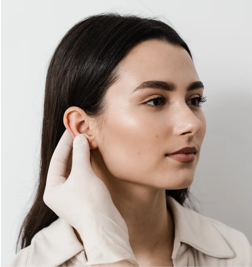 Woman in profile with hand near ear, showing natural ear appearance post-otoplasty