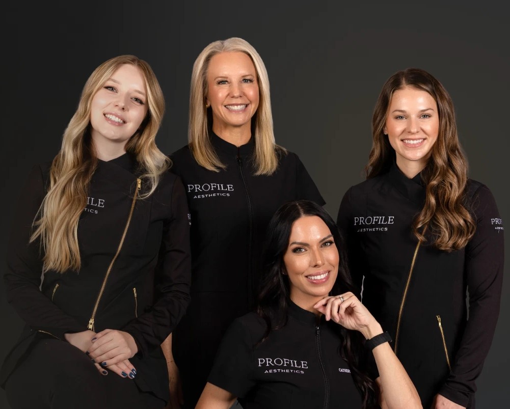 Catherine Marben and three team members wearing Profile Aesthetics branded black jackets, smiling at camera