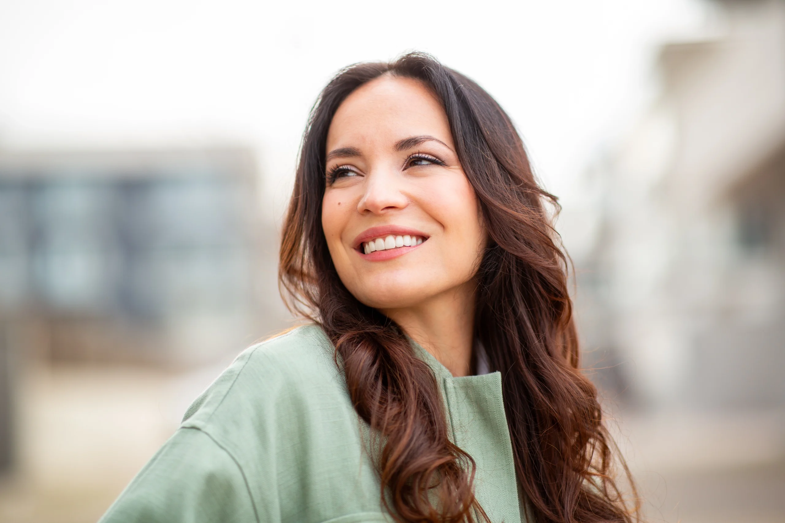 Calm woman with long wavy hair in a quiet outdoor setting