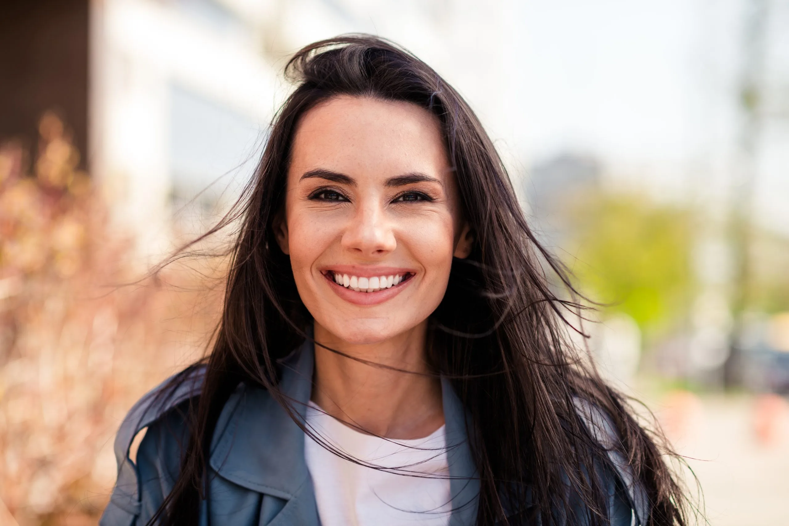 Smiling woman with long dark hair outdoors