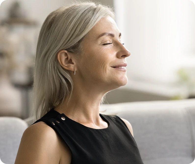 Calm, hopeful woman sitting peacefully indoors