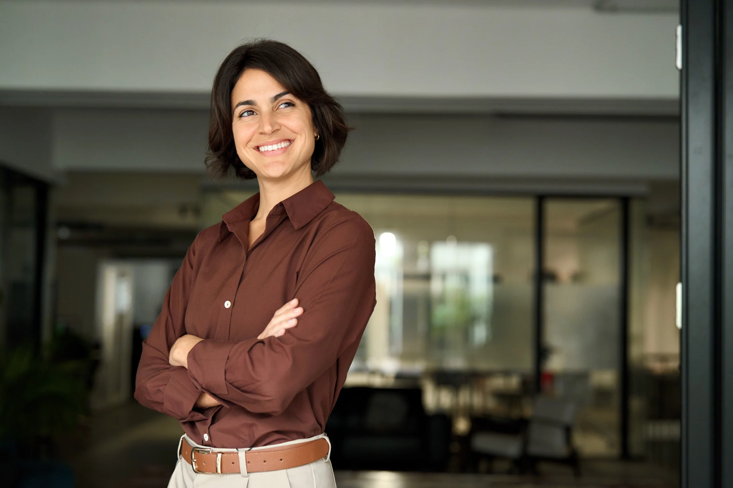 Smiling professional woman with arms crossed in an office