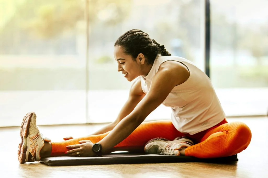 Woman stretching on a yoga mat in a bright studio