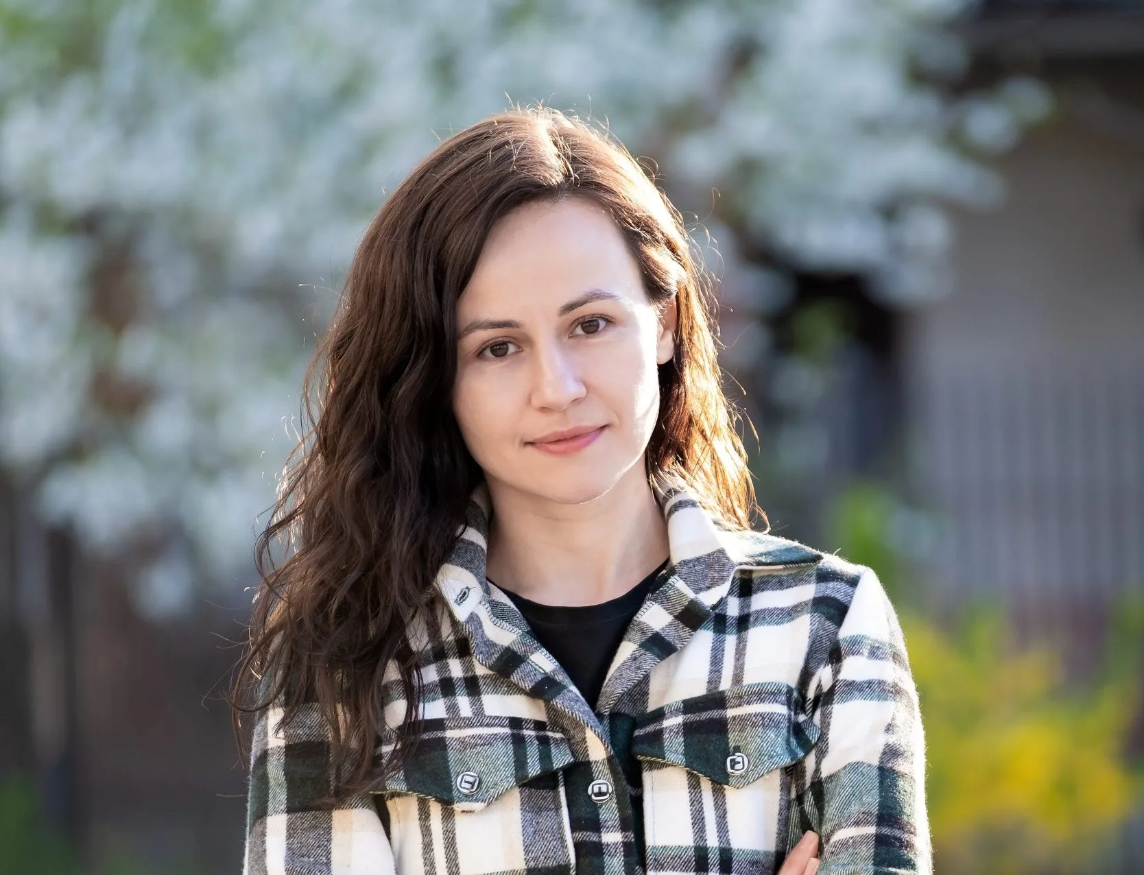 Smiling woman outdoors in a plaid shirt
