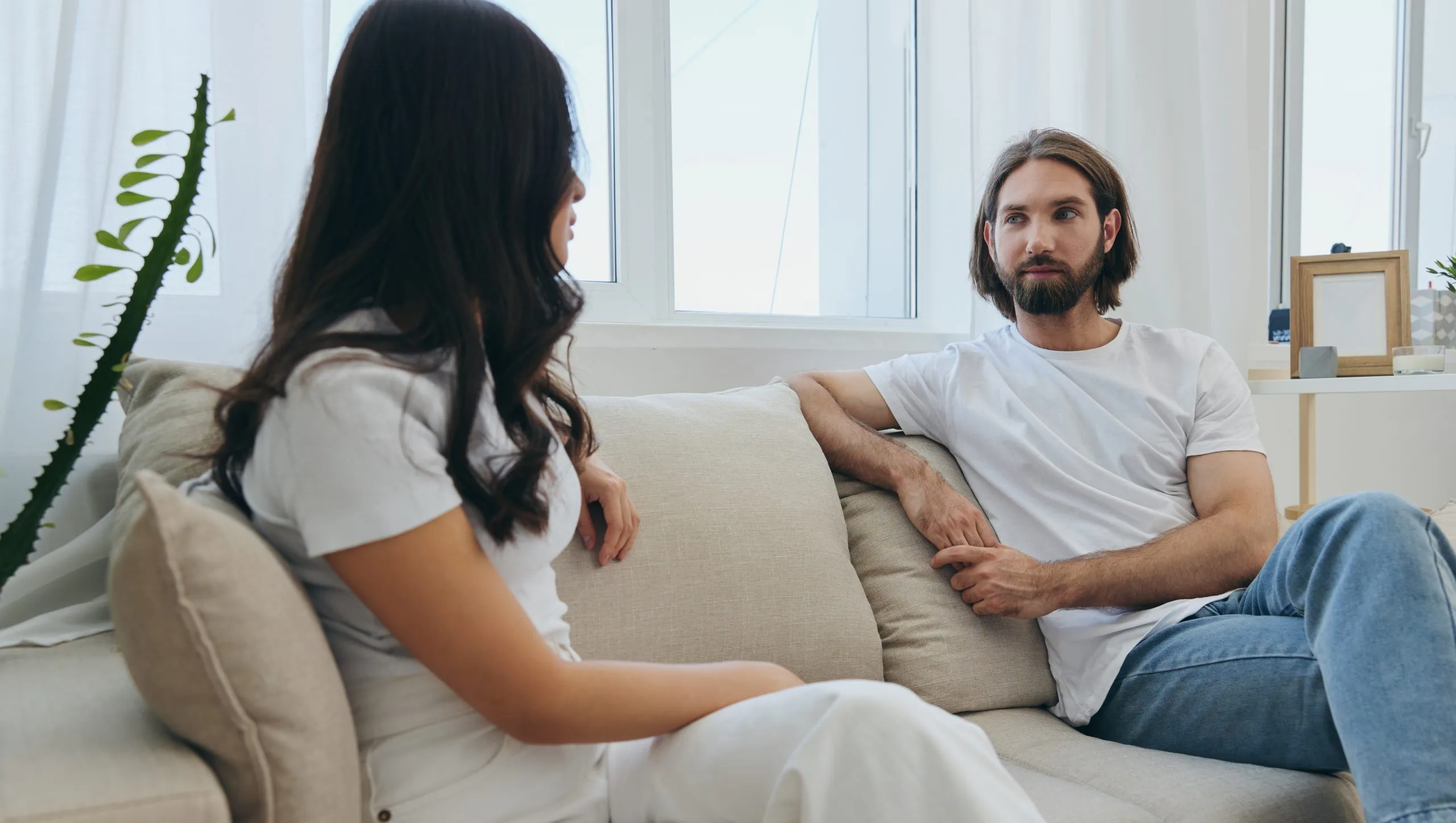 Man and woman talking on a couch