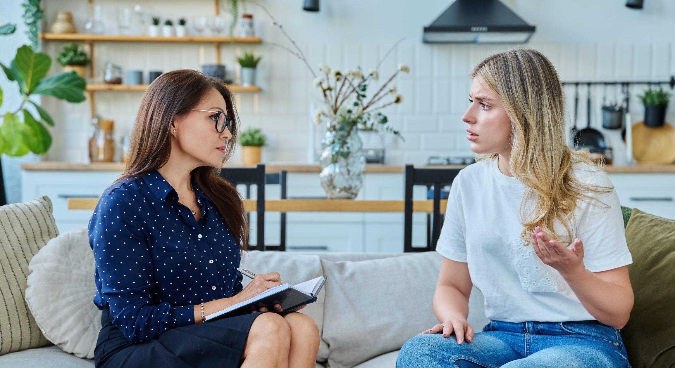 Counselor taking notes with a young woman
