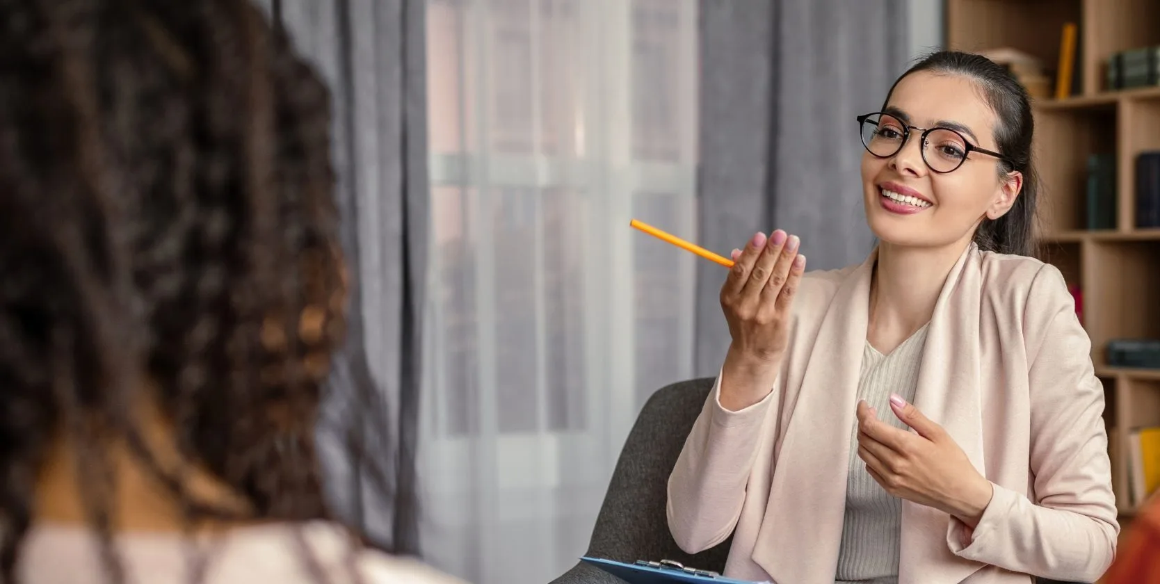 Therapist with glasses talking with a client