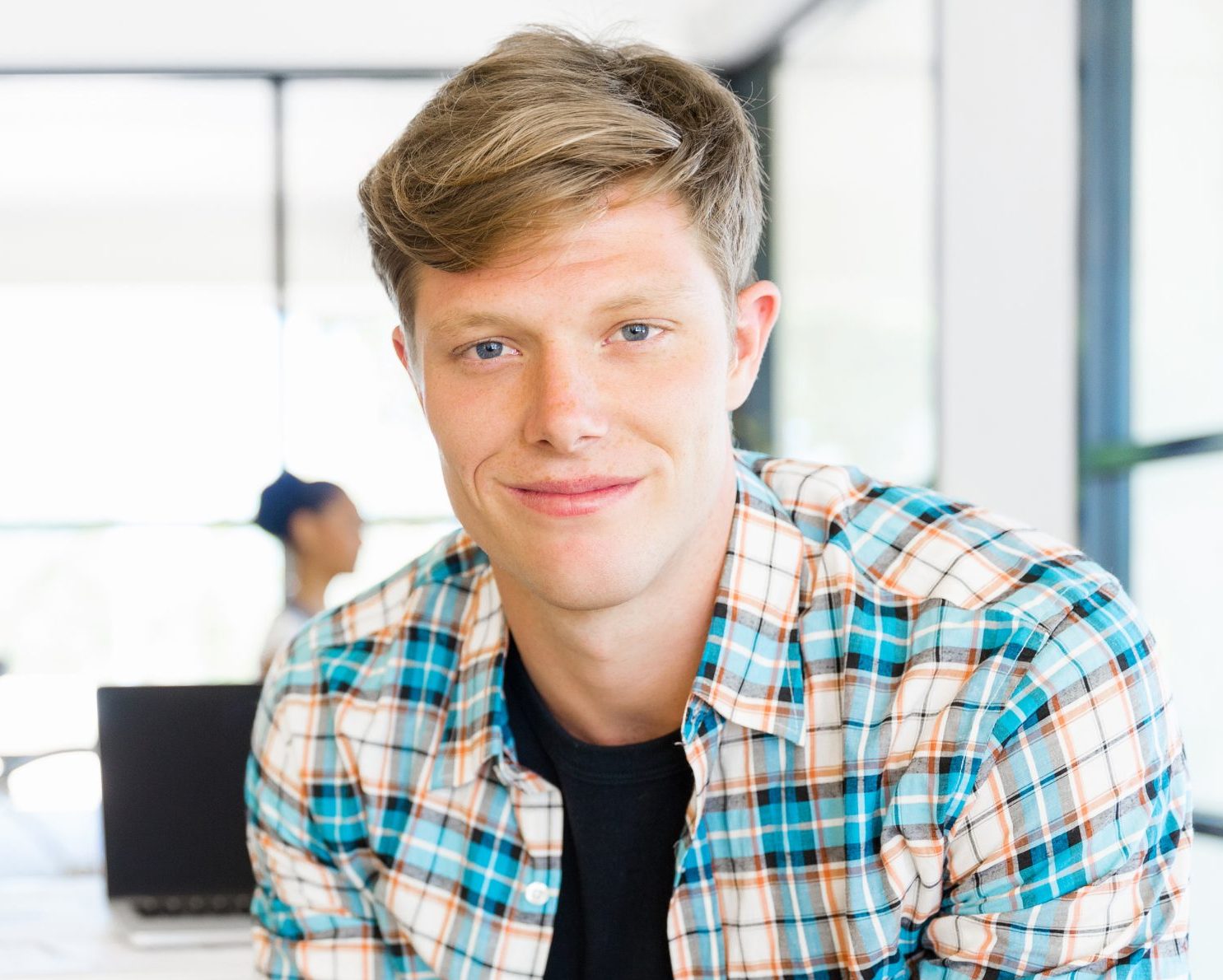 Smiling young man in a plaid shirt