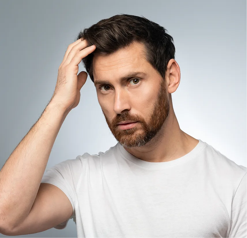 Man touching his hair against a neutral background