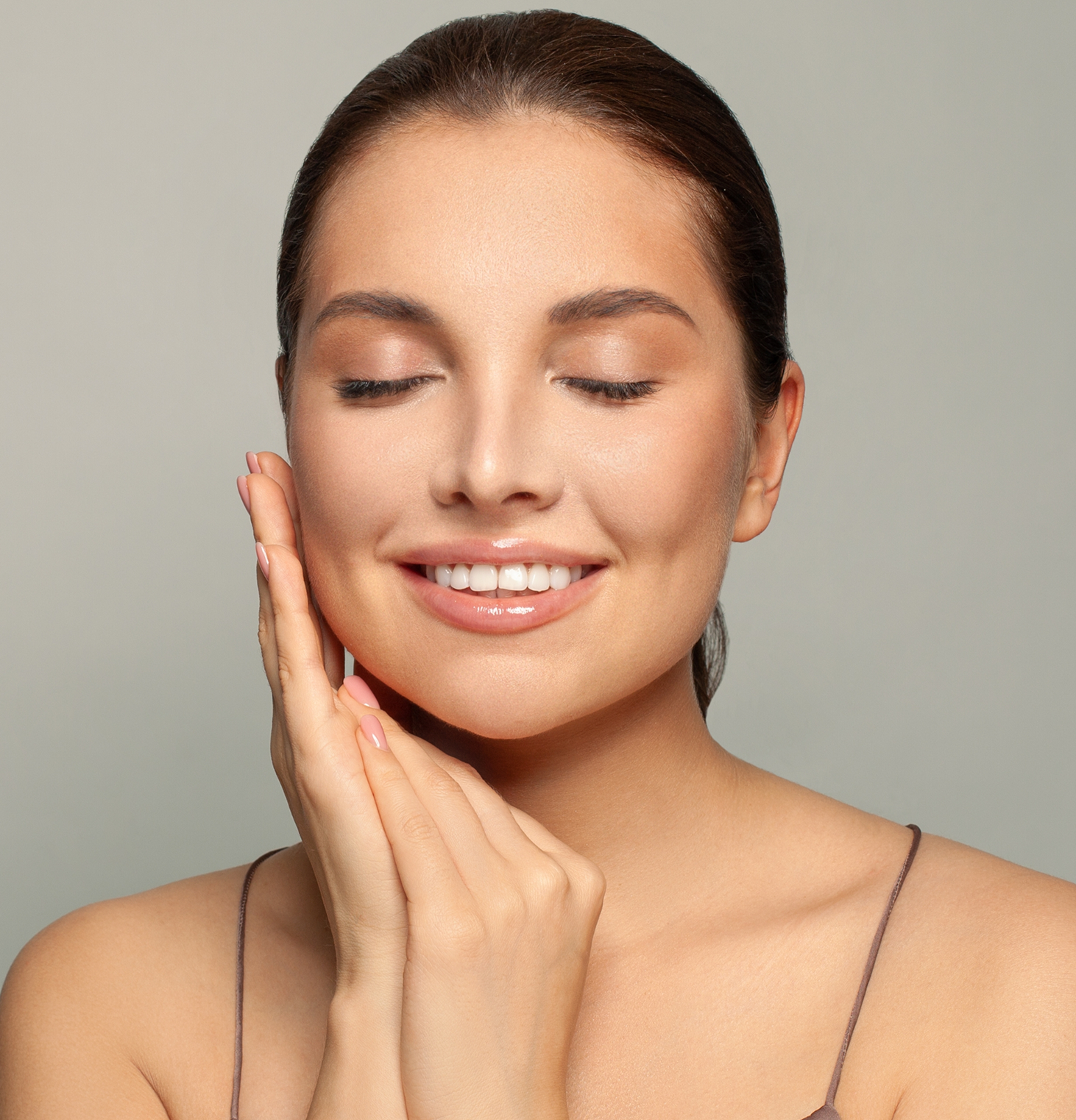 Woman with glowing skin touching her face and smiling, demonstrating results from PRP injections