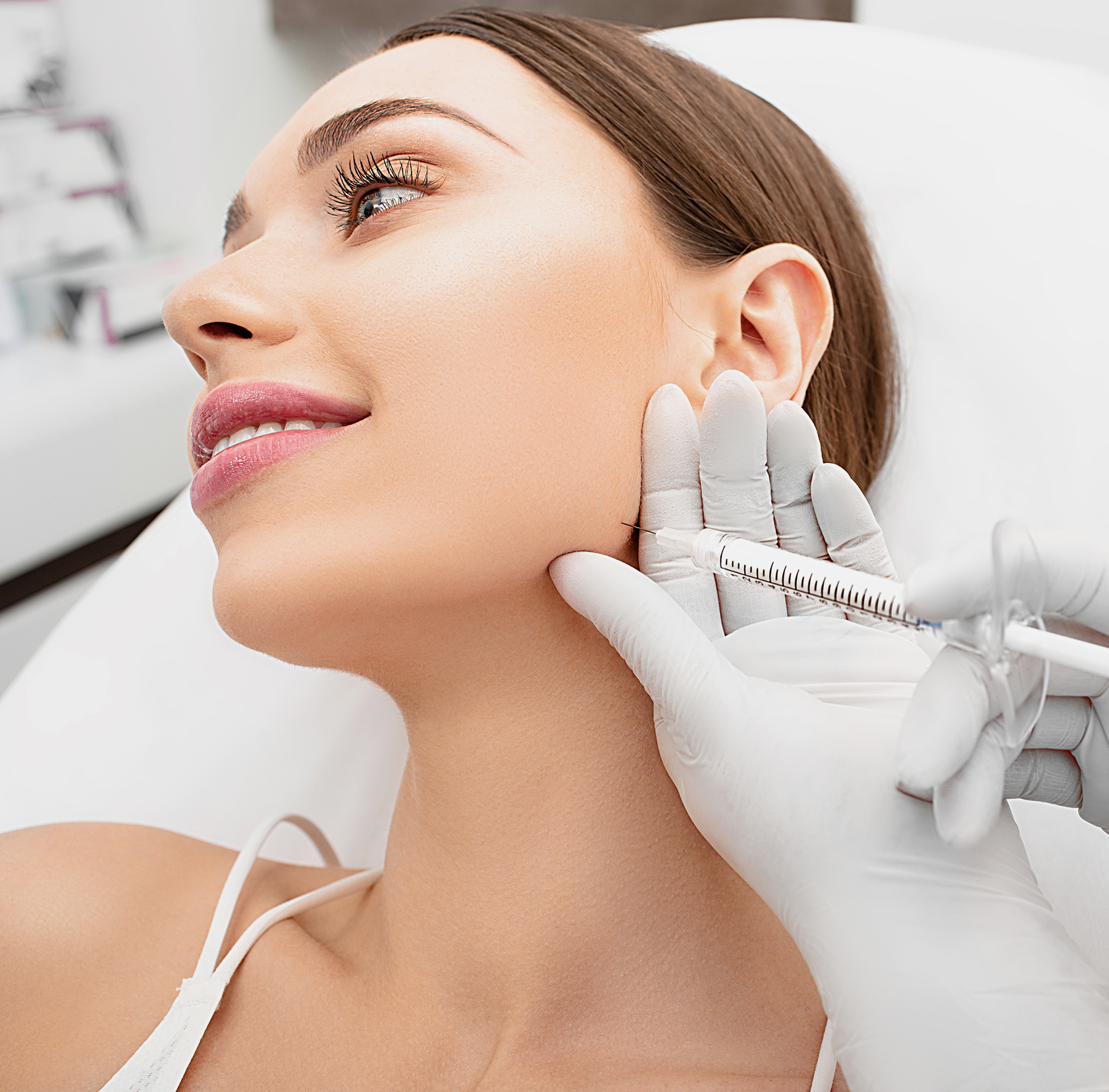 Clinician injecting Juvederm filler into patient's cheek during cosmetic treatment